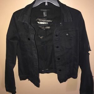 Black denim jacket with distressed back and arm.